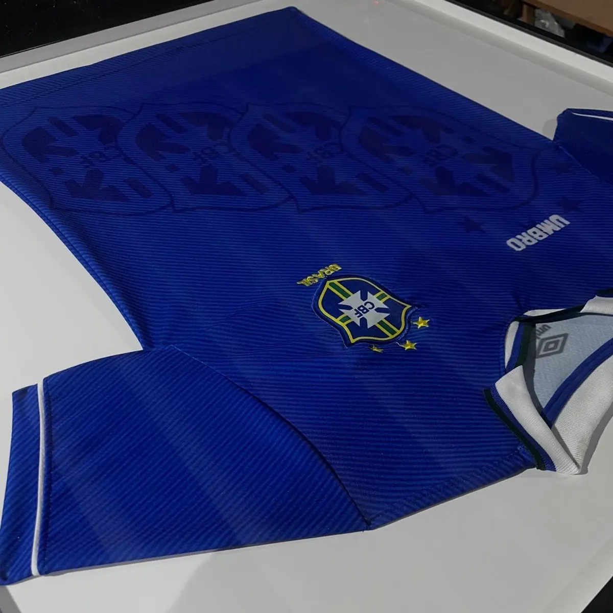 Camisa azul da Seleção Brasileira Umbro emoldurada com fundo branco