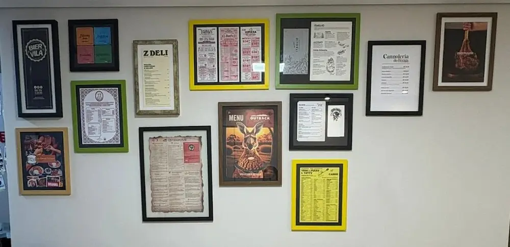 Parede com cardápios de restaurantes emoldurados em molduras coloridas